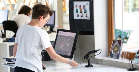 Enfant à l'automate de prêts de la médiathèque de La Parenthèse.